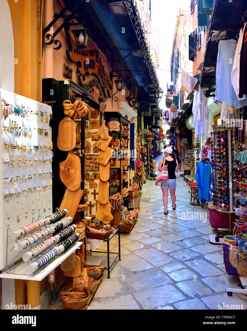 Turista femminile,a piedi attraverso Corfù città vecchia,negozi di souvenir,strada stretta,negozi,CORFU, ISOLE IONIE,isole greche,Grecia Foto Stock