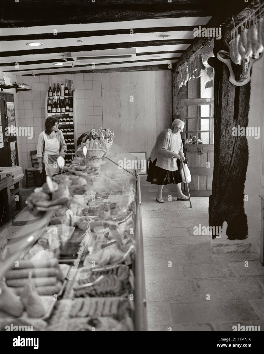 Francia, Borgogna, senior Donna che cammina con la canna da zucchero in Charcutier, Noyers (B&W) Foto Stock