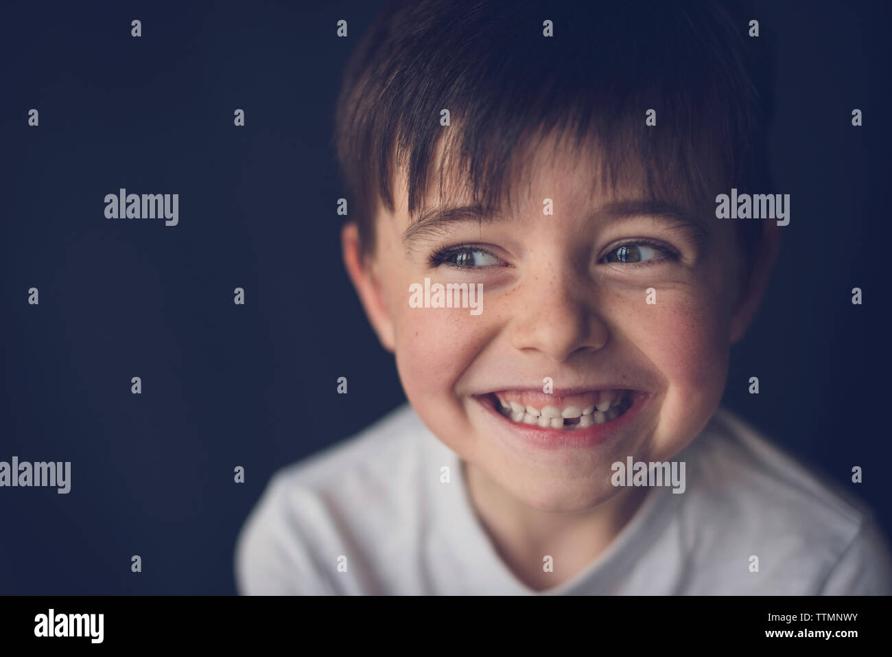 Close-up di allegro ragazzo di denti di aggraffaggio guardando attraverso lateralmente sintesi Foto Stock