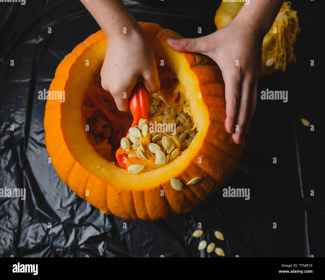 Mani tagliate la rimozione di semi di zucca a casa Foto Stock