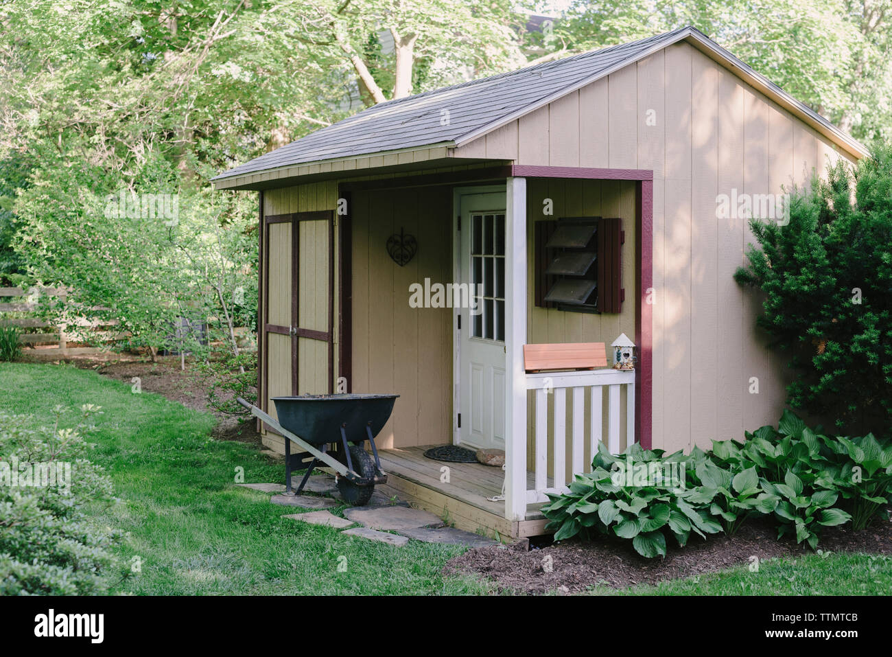 Carriola al di fuori del capannone nel giardino Foto Stock