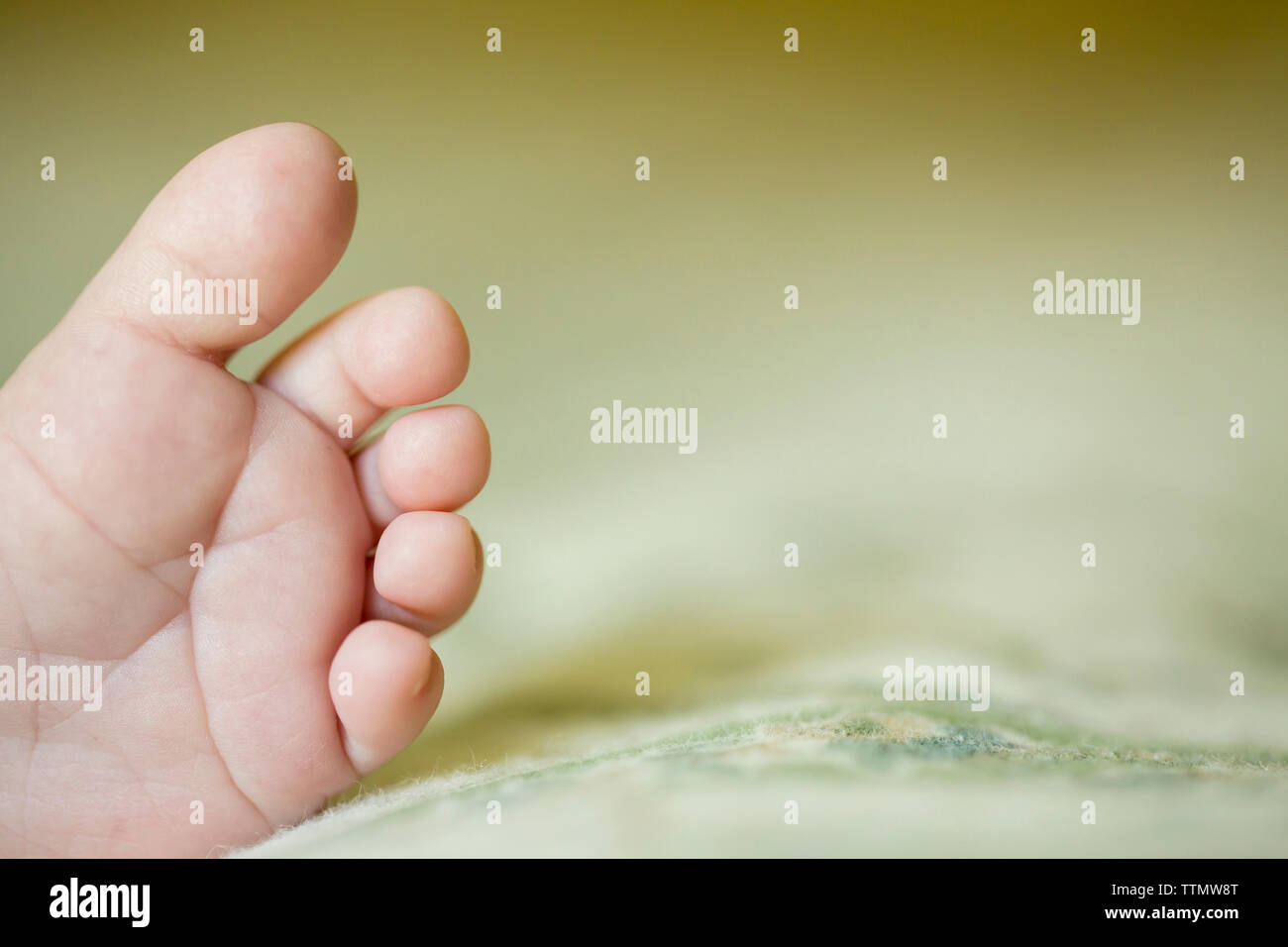 Tagliate il piede del bambino sul letto di casa Foto Stock