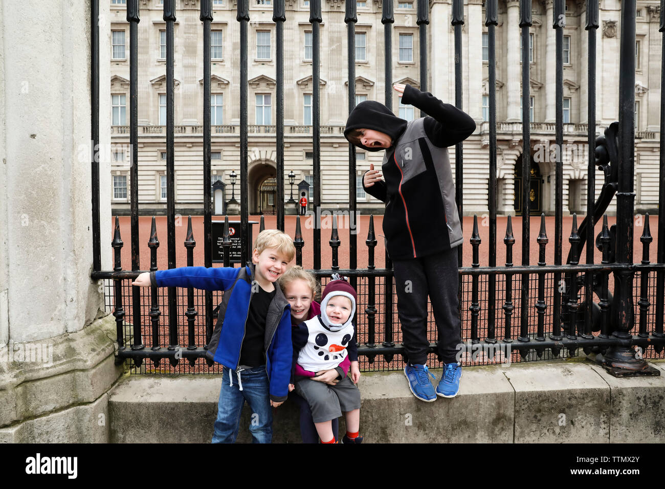 Quattro fratelli essendo Silly presso il cancello del Palazzo di Buckingham Foto Stock