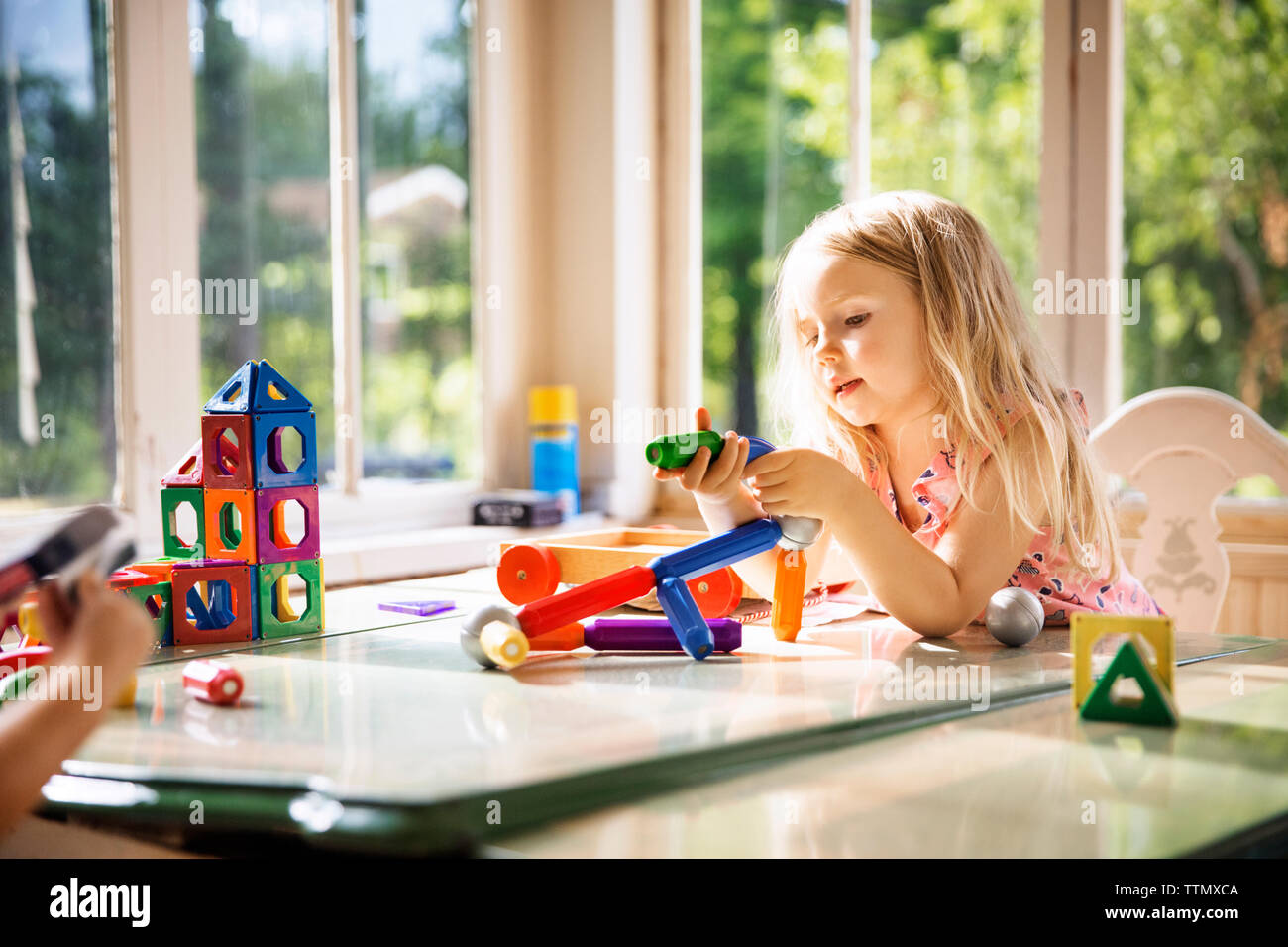Ragazza che gioca con la costruzione di blocchi a casa Foto Stock