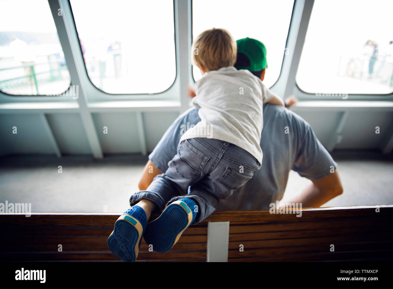 Vista posteriore del padre e figlio in viaggio in traghetto Foto Stock