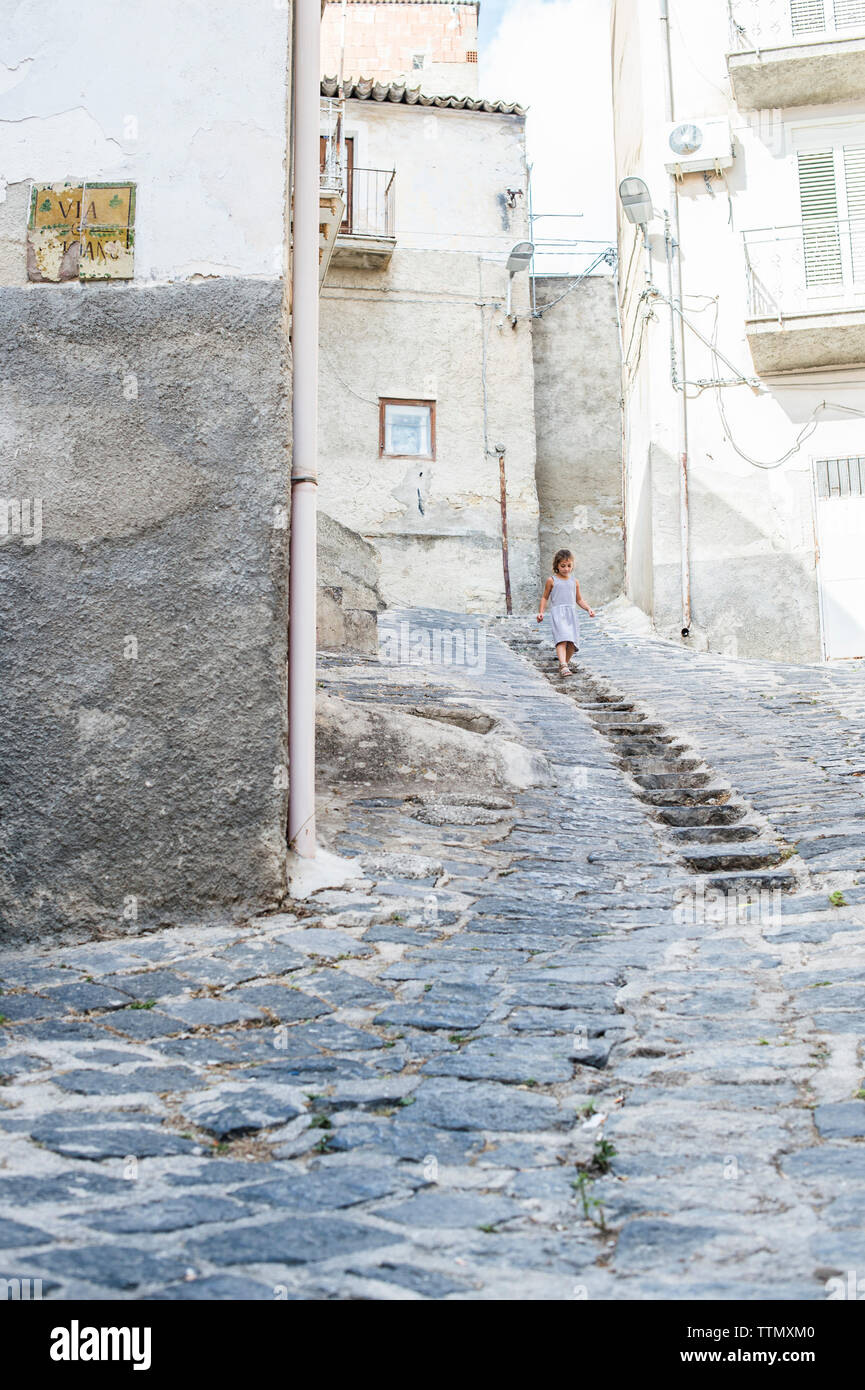 La ragazza si sta spostando verso il basso le fasi in mezzo su edifici Foto Stock
