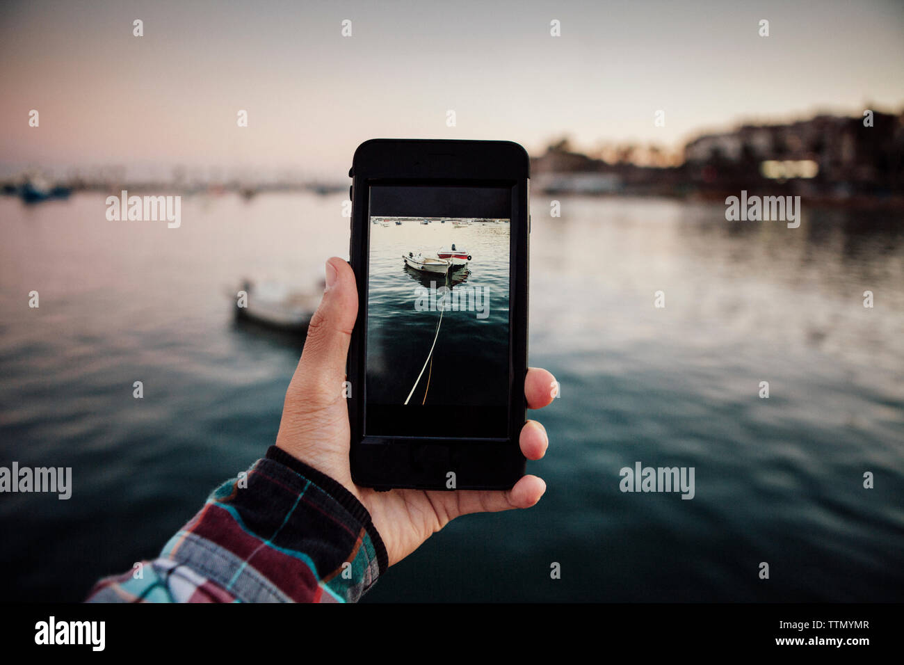 Immagine ritagliata dell'uomo fotografare legata barche ormeggiate in mare Foto Stock