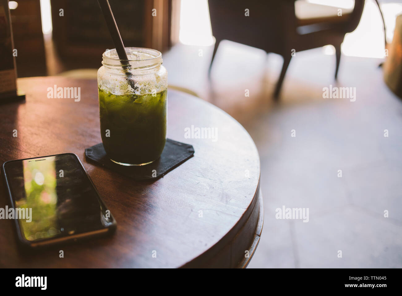 Close-up di bere da smart phone sul tavolo Foto Stock