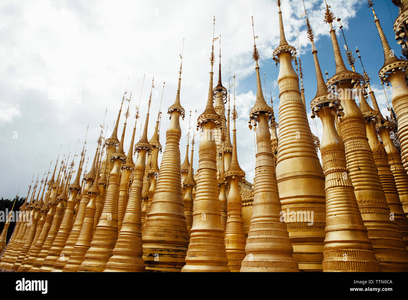 Basso angolo di vista stupas a Shwe Indein Pagoda contro sky Foto Stock