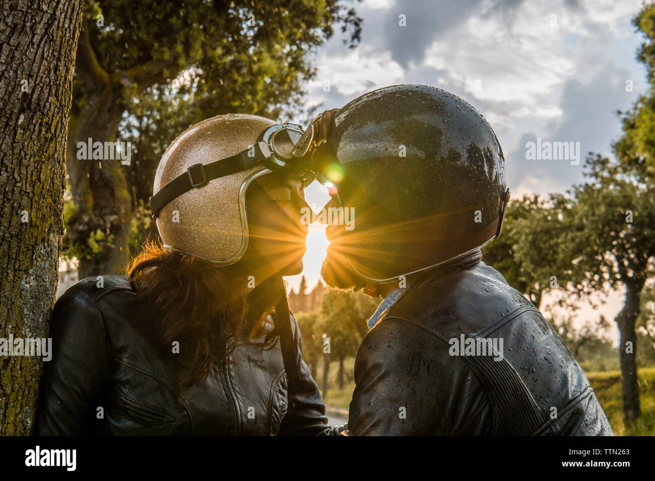 Coppia romantica baciare mentre in piedi contro il cielo durante il tramonto Foto Stock