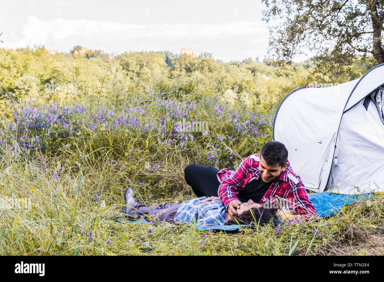 Coppia romantica rilassante sulla copertura in corrispondenza di campeggio nel bosco Foto Stock
