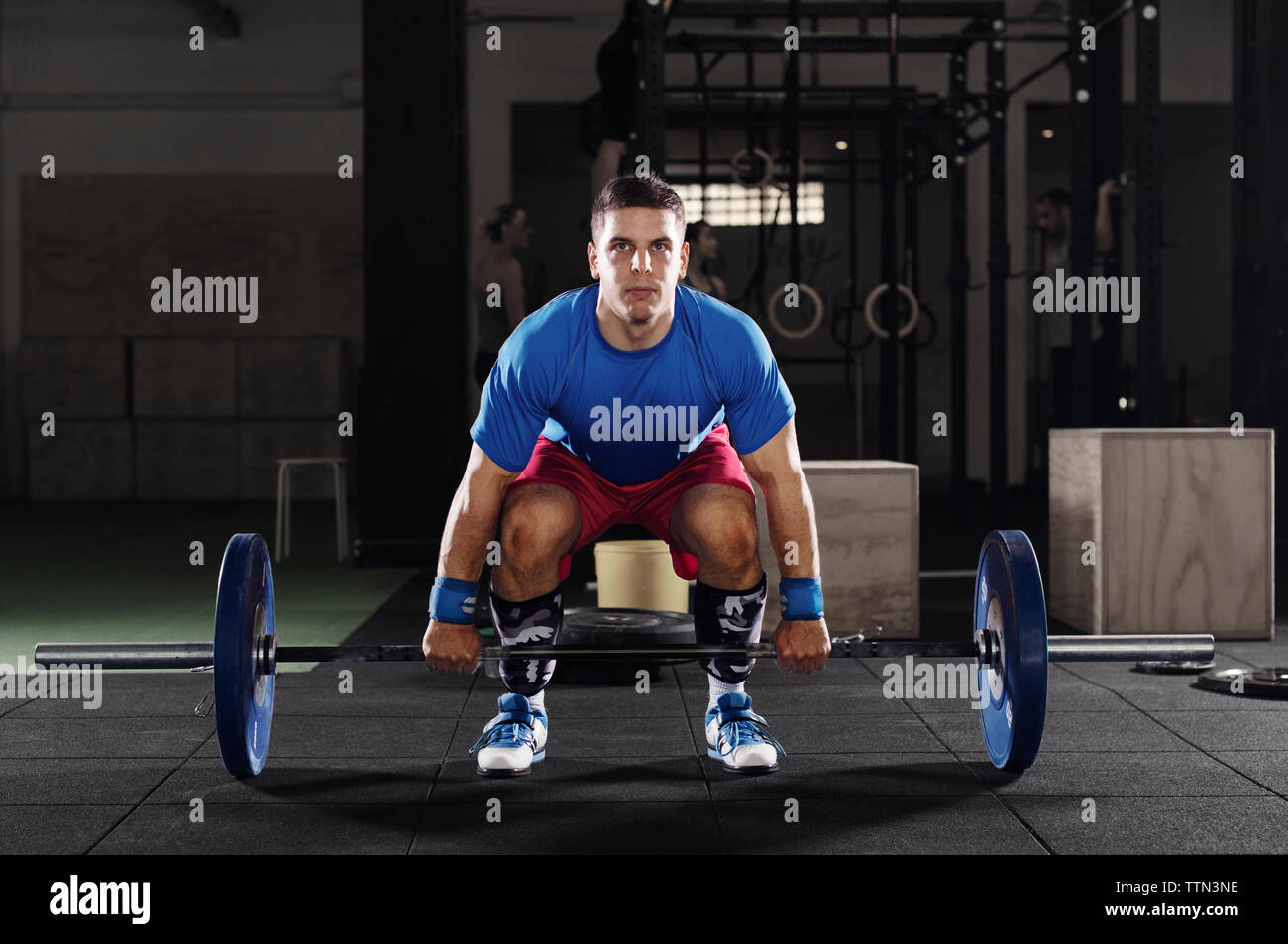 Ritratto di determinata atleta maschio il sollevamento barbell in palestra Foto Stock
