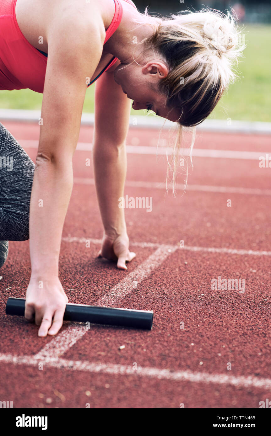 Atleta con relè baton sulla via Foto Stock