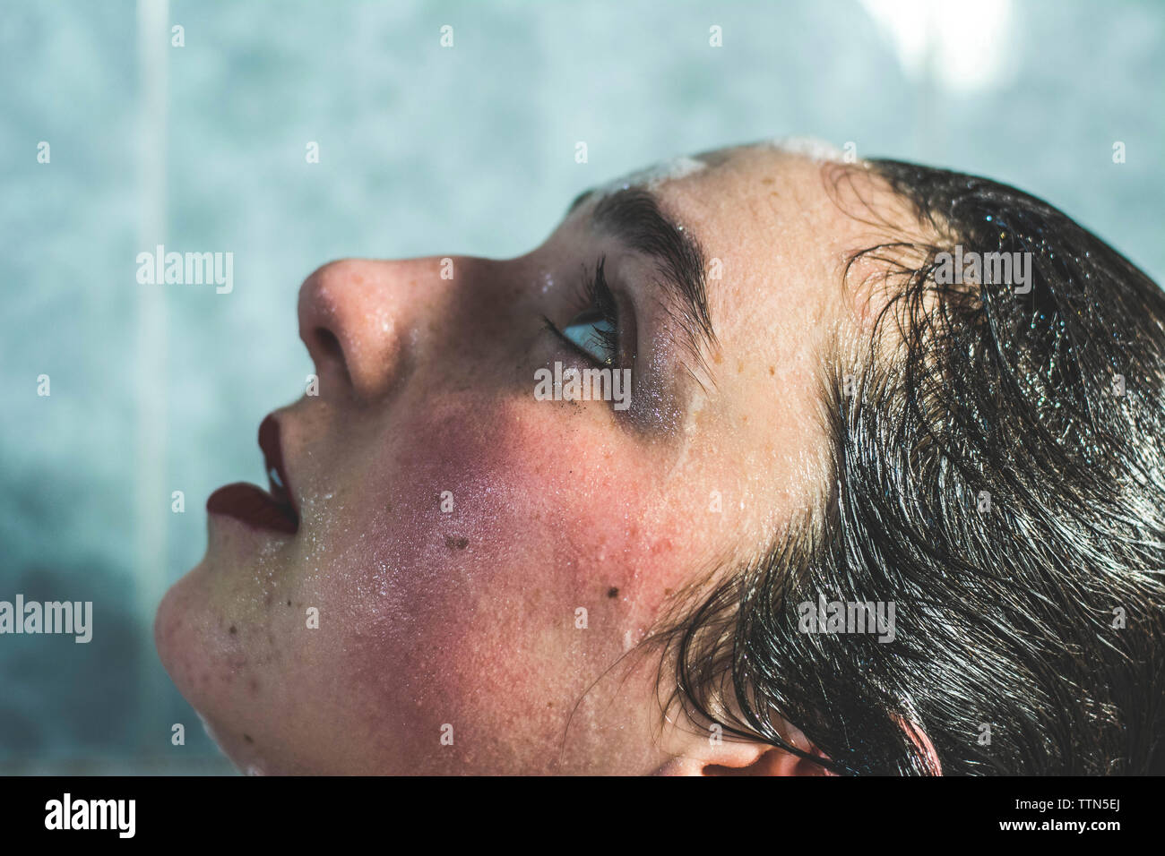 Close-up di wet giovane donna con il make-up cercando mentre la balneazione in bagno a casa Foto Stock