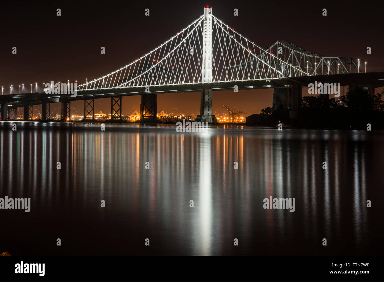 Illuminata Oakland Bay Bridge oltre l'isola del tesoro nella città di notte Foto Stock