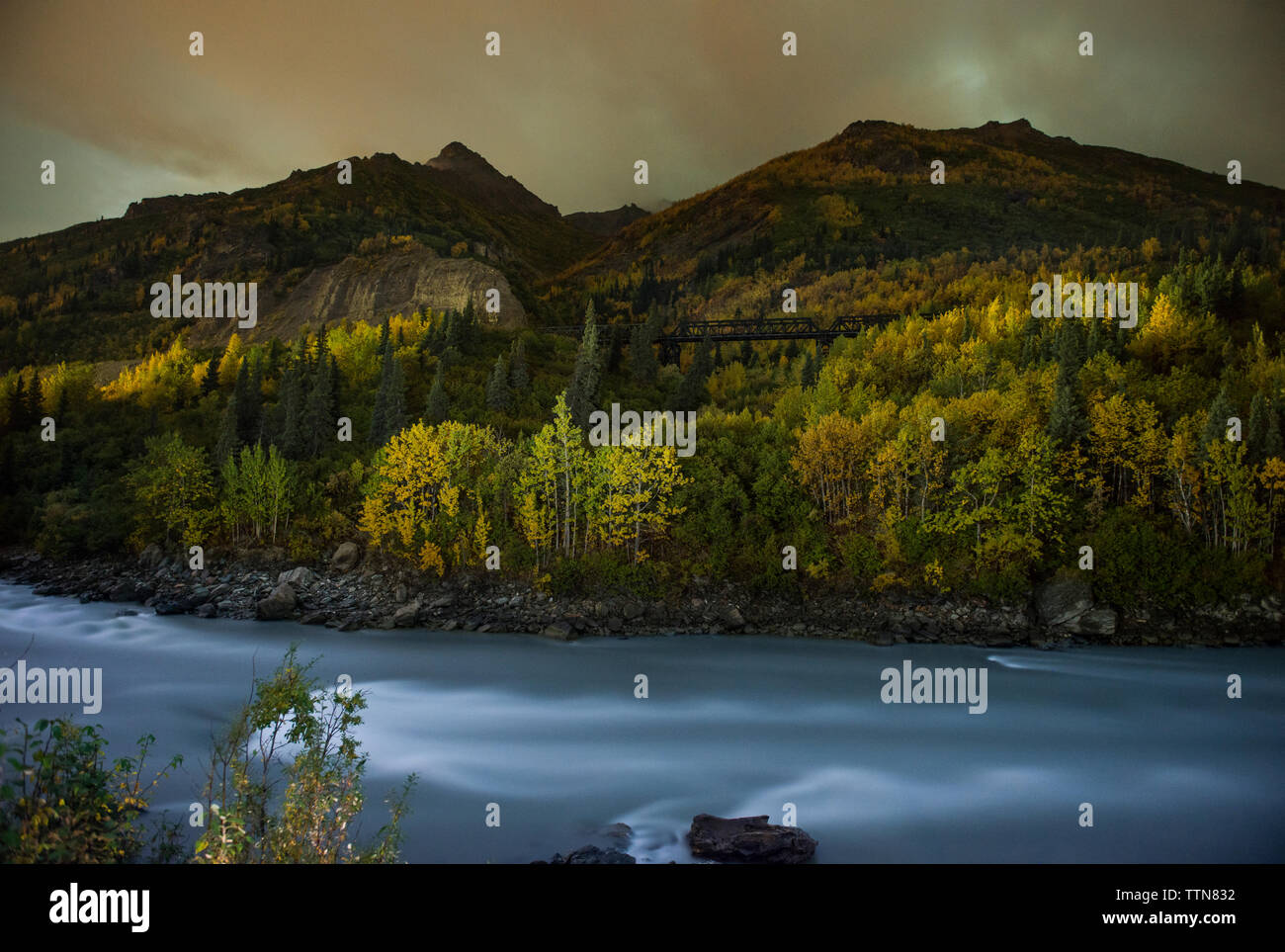 Una lunga esposizione del fiume da alberi contro il cielo Foto Stock