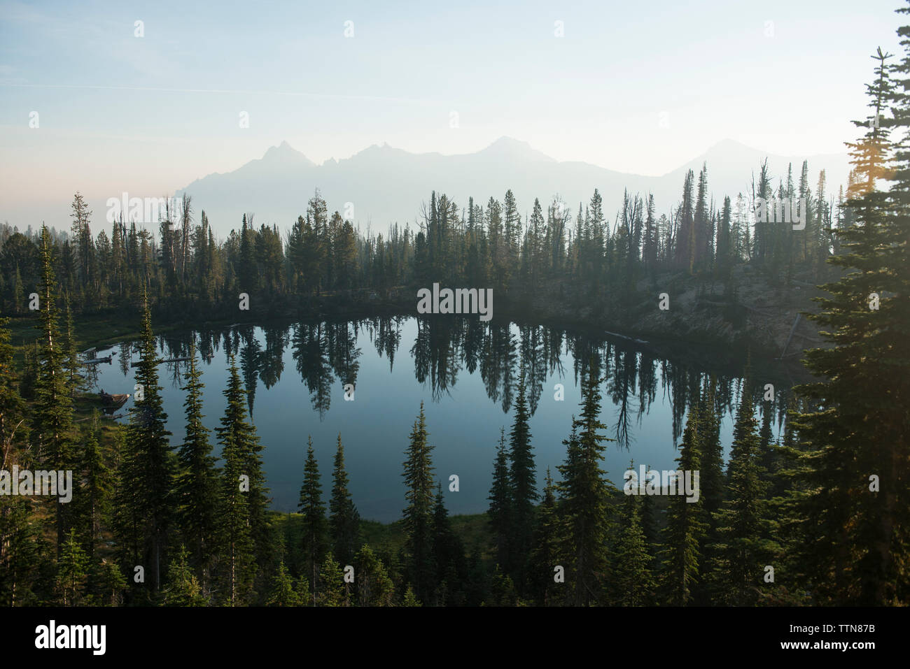 Il lago in mezzo di alberi a gamma a dente di sega contro sky Foto Stock