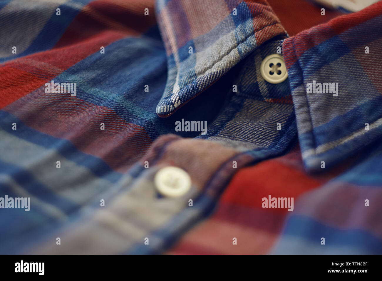 Parte della camicia in rosso e blu, a scacchi dove vi è anche un collare e pulsanti bianchi Foto Stock