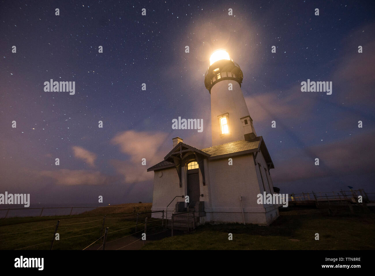 Angolo basso una vista maestosa del faro illuminato contro star campo a Cape Blanco parco dello stato Foto Stock