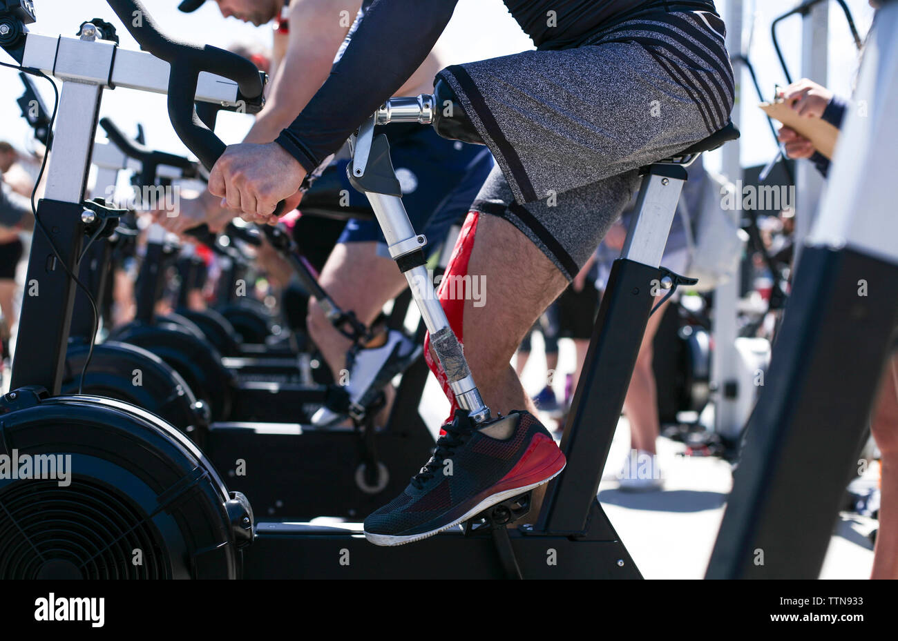 Sezione bassa di atleta adattativo che esercitano sulla cyclette all'aperto Foto Stock