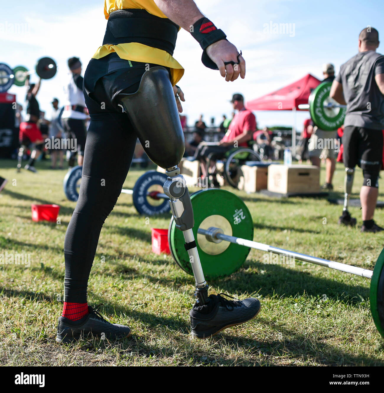 Sezione bassa del maschio atleta adattativa in piedi da deadlift sul campo erboso a park Foto Stock