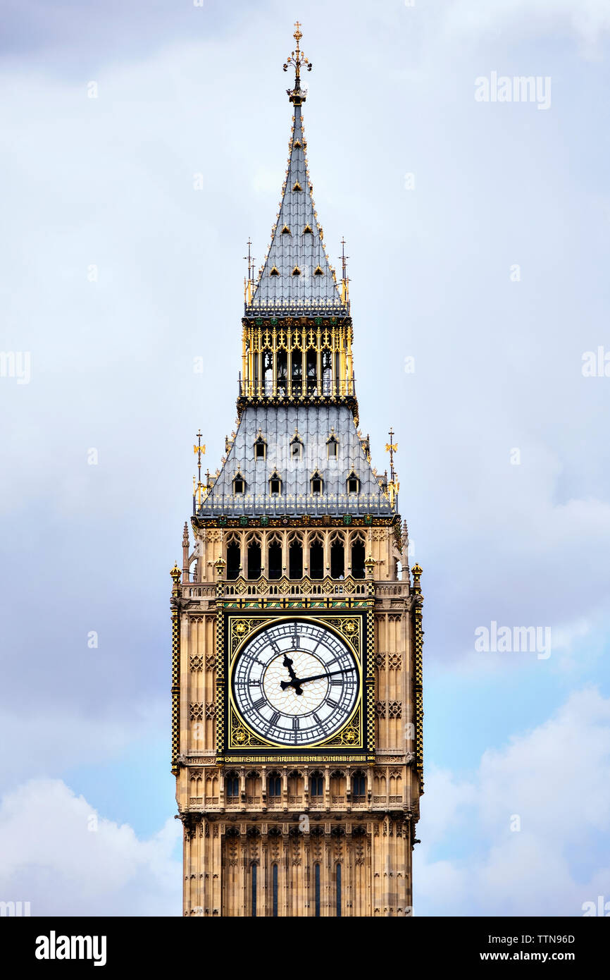 Sezione alta del Big Ben contro il cielo nuvoloso Foto Stock