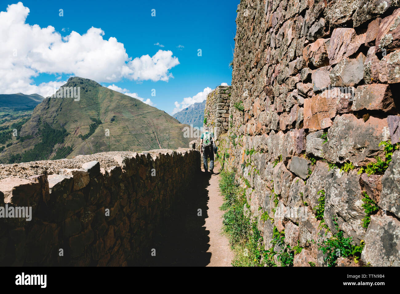 Vista posteriore di un escursionista a piedi da vecchi ruderi contro il cielo di Pisac Foto Stock