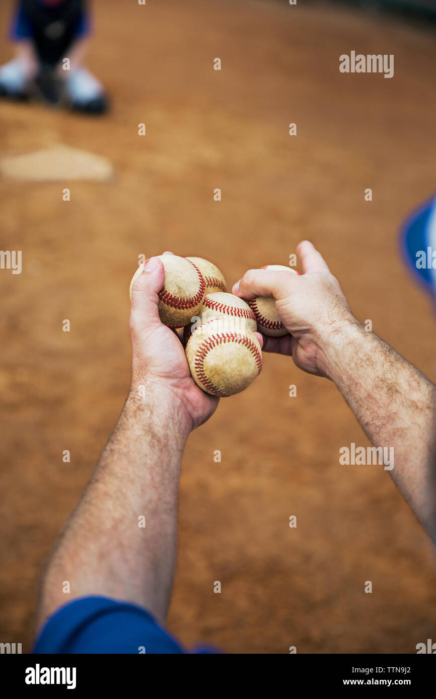 Immagine ritagliata di coach holding baseballs sul campo Foto Stock