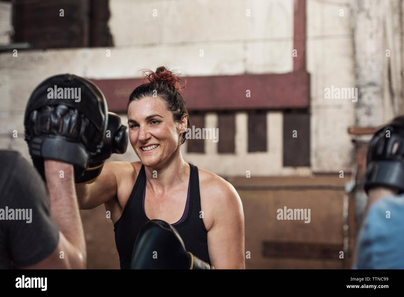 Felice boxer femmina praticando con maschio amico in palestra Foto Stock