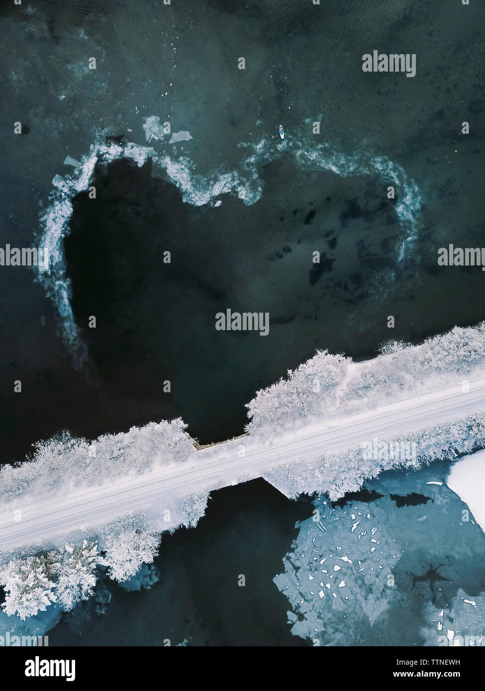 Angolo di Alta Vista della coperta di neve ponte sul lago ghiacciato durante il periodo invernale Foto Stock