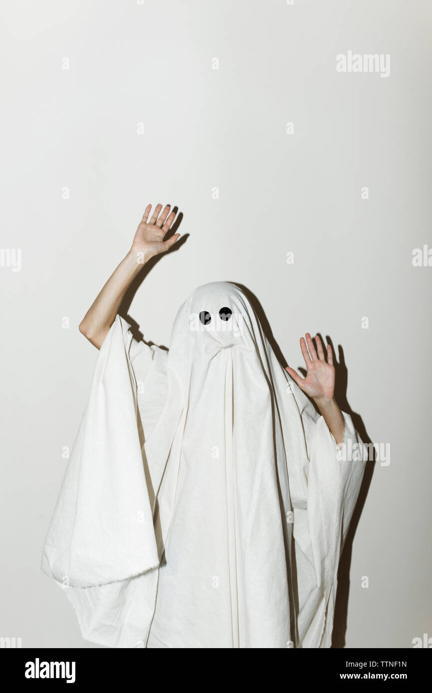 Uomo in costume fantasma gesticolando mentre in piedi contro la parete Foto Stock