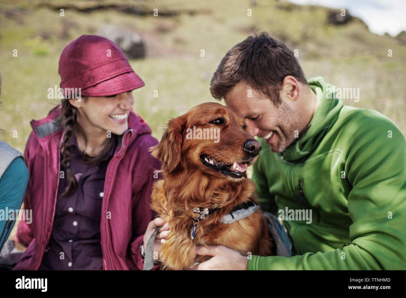 Felici gli escursionisti con il cane seduto sulla collina Foto Stock