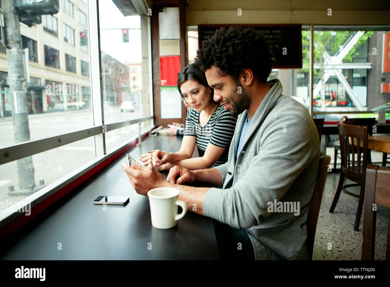 Multi-etnico giovane utilizzando computer tablet in cafe Foto Stock