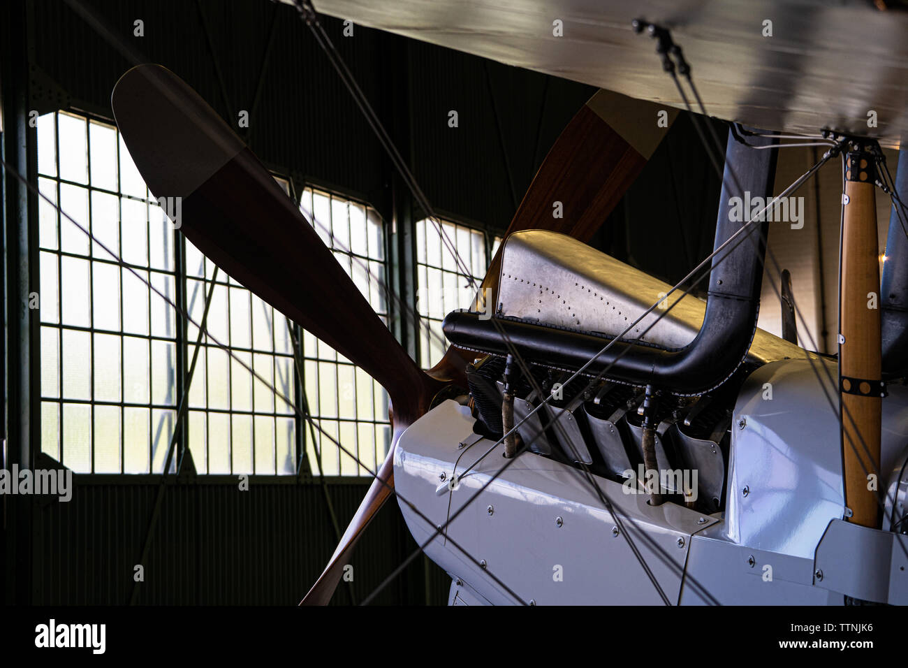 Historic bi-plane silhouette / rim-accesa all'interno di un hangar Foto Stock