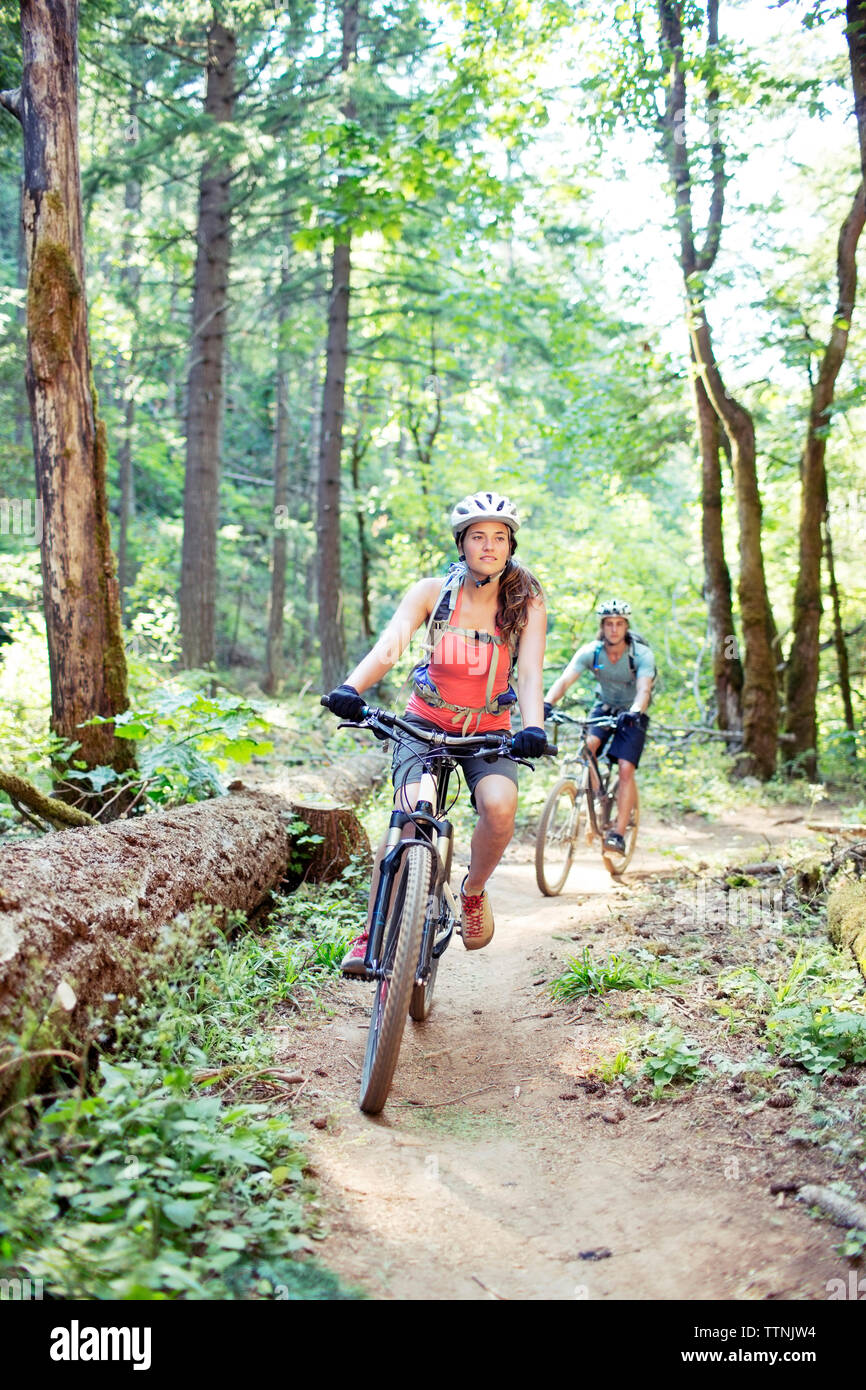 Giovane equitazione bicicletta su strada sterrata nel bosco Foto Stock