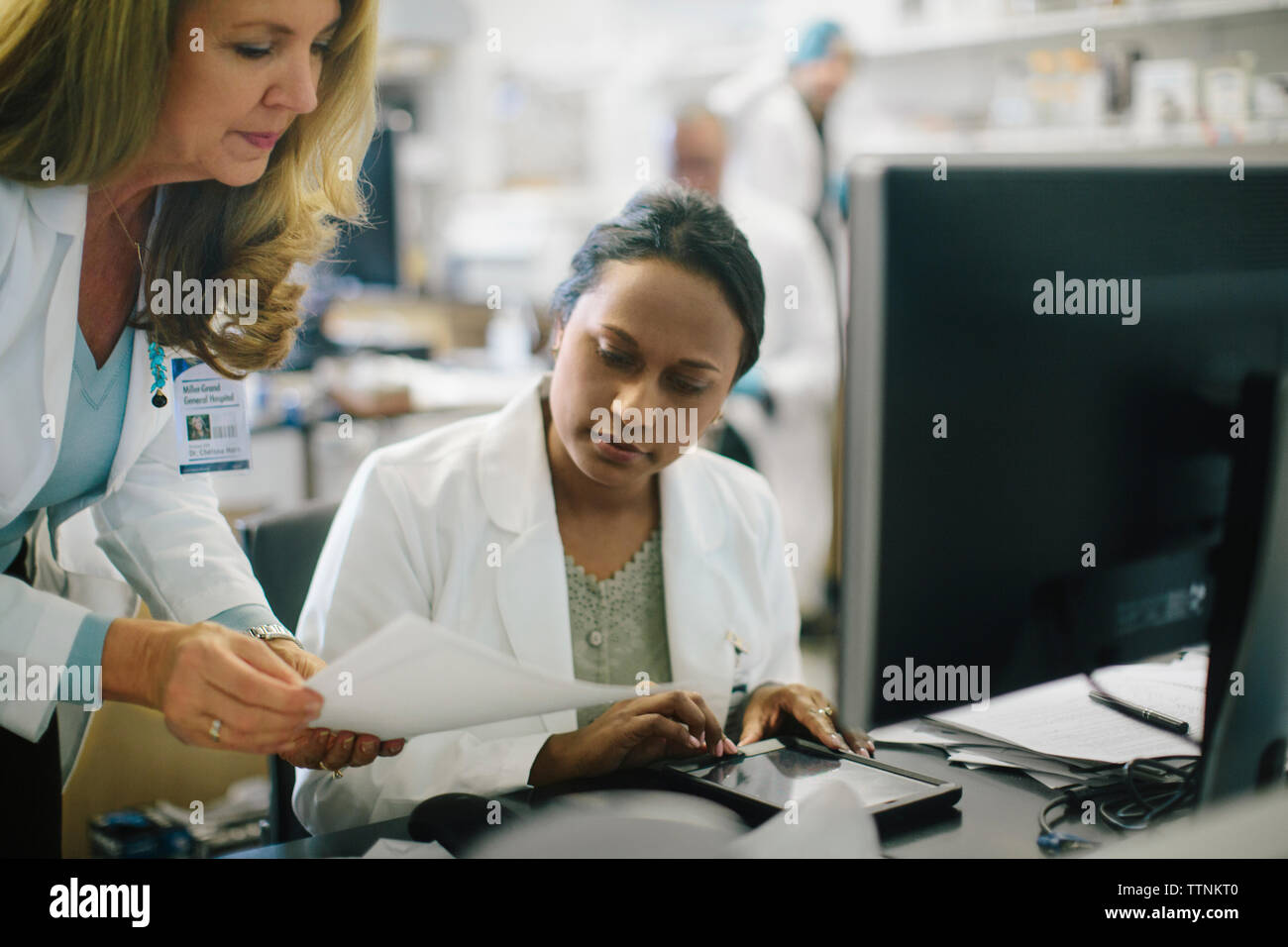 Medico donna che mostra i rapporti a un collega in sala medica Foto Stock