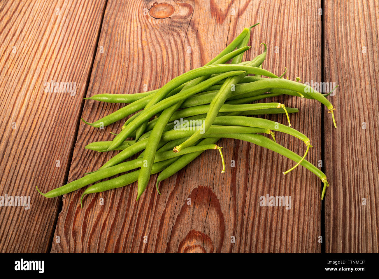 I fagiolini gruppo su uno sfondo di legno Foto Stock