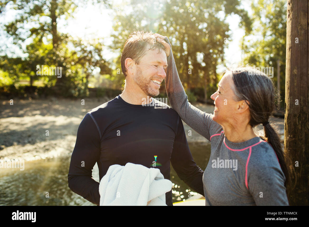 Felice donna uomo tira i capelli mentre in piedi dal fiume Foto Stock