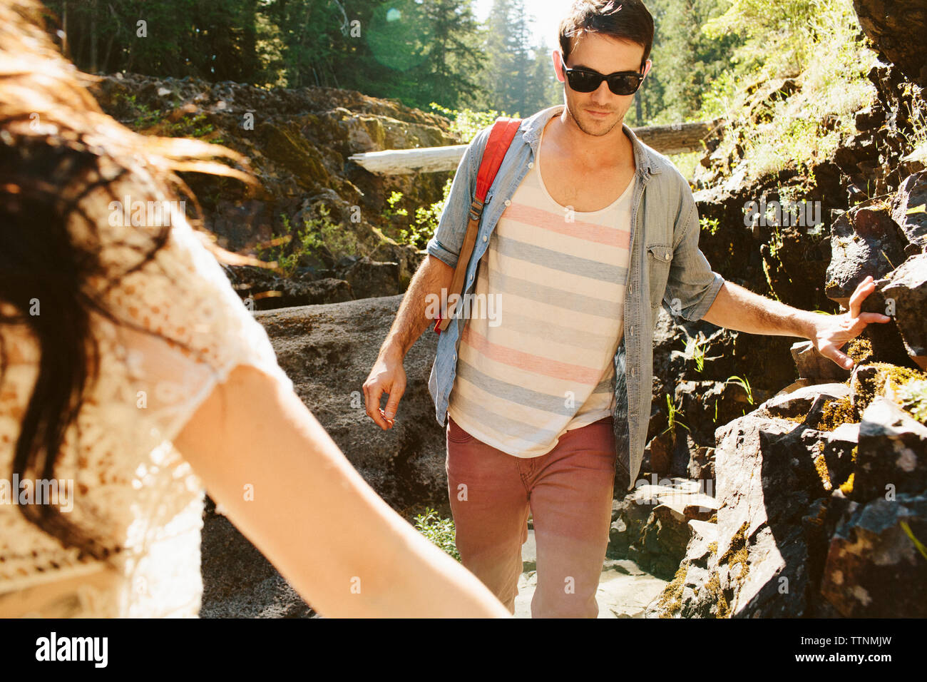 Ritagliate la mano della donna con escursioni amico maschio in foresta Foto Stock