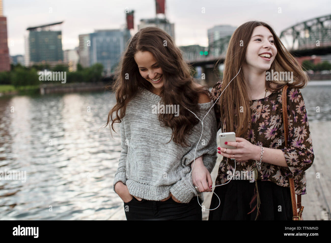 Sorridente in amici ascoltare musica mentre è in piedi contro la Burlington Northern ponte ferroviario 9.6 Foto Stock