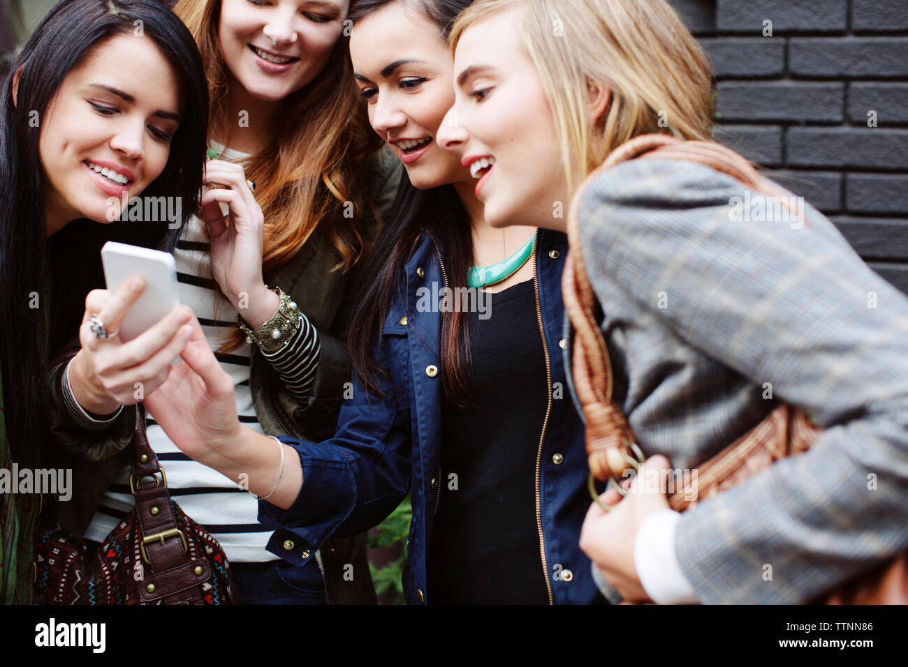 Happy amici di sesso femminile guardando al telefono cellulare Foto Stock