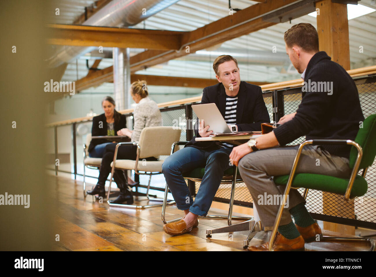 uomini d'affari che lavorano ai tavoli in ufficio Foto Stock