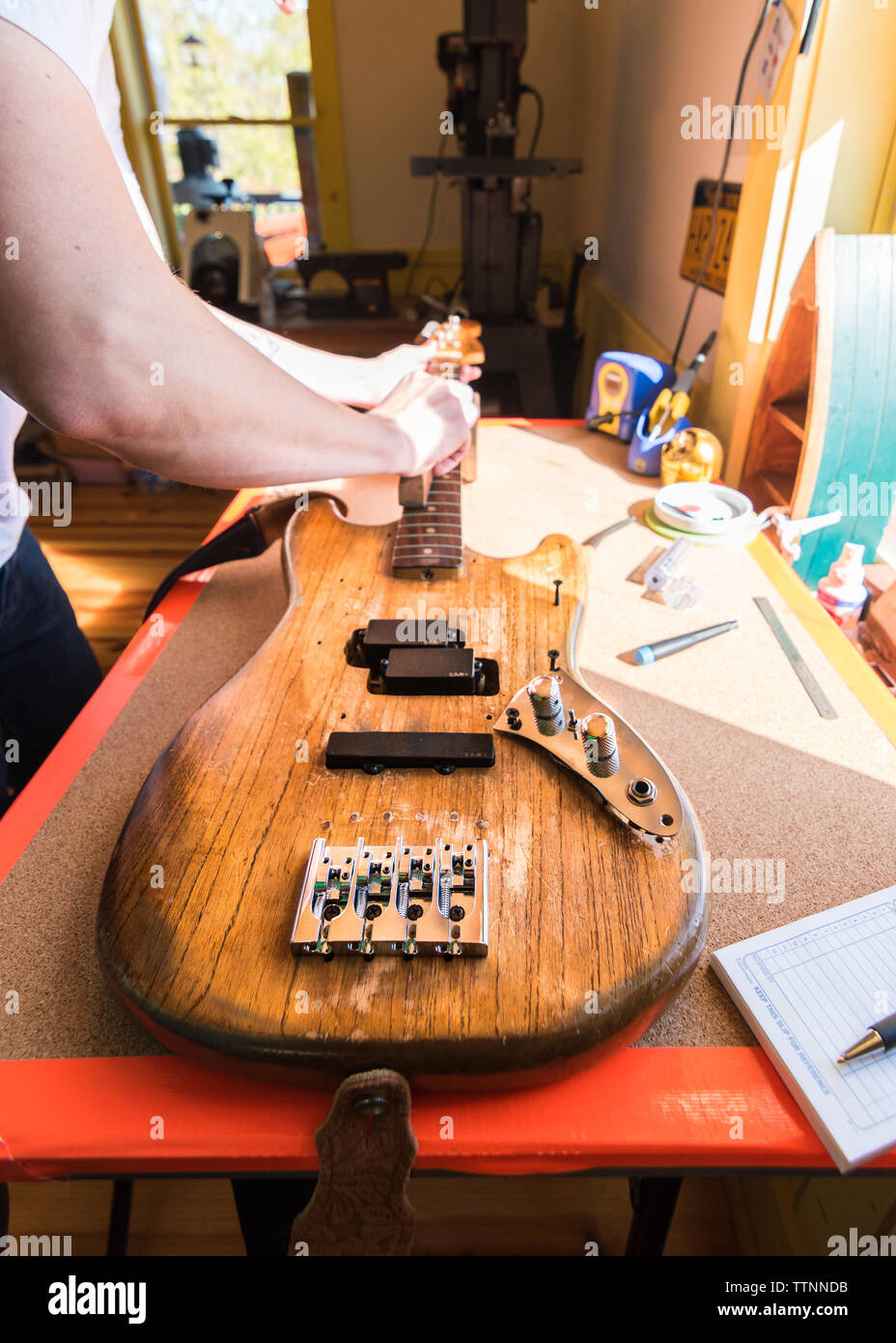 Luthrie Finitura collo di chitarra in officina per la lavorazione del legno per artista locale Foto Stock