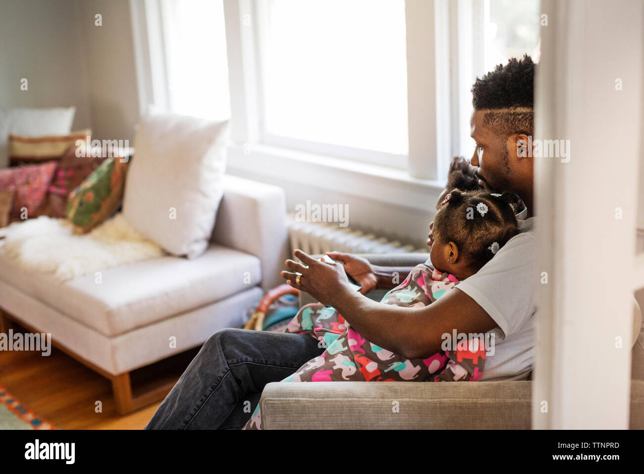 Vista laterale del padre utilizzando computer tablet con bambini in soggiorno Foto Stock