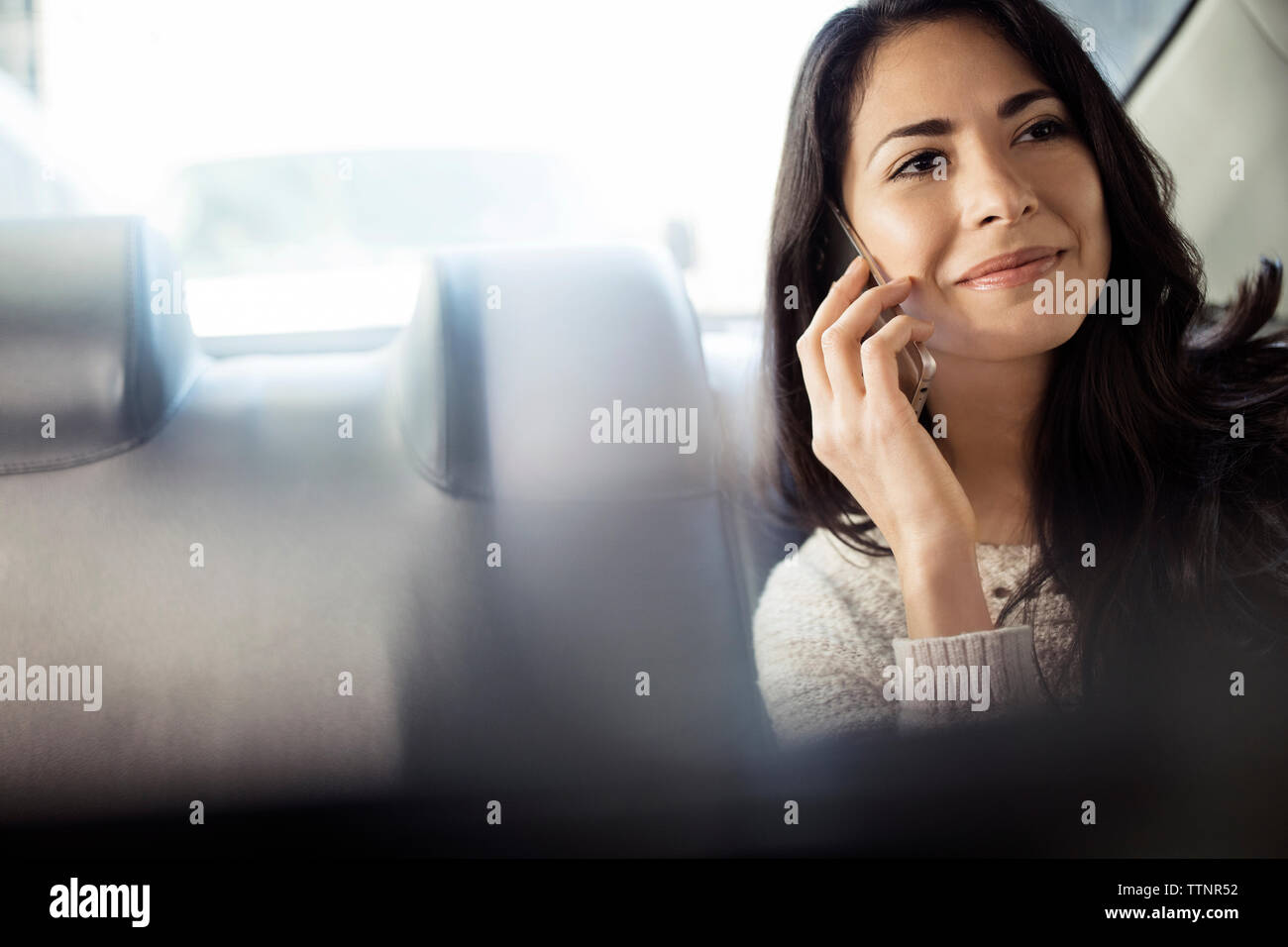 Bella donna rispondendo alle smart phone in taxi Foto Stock