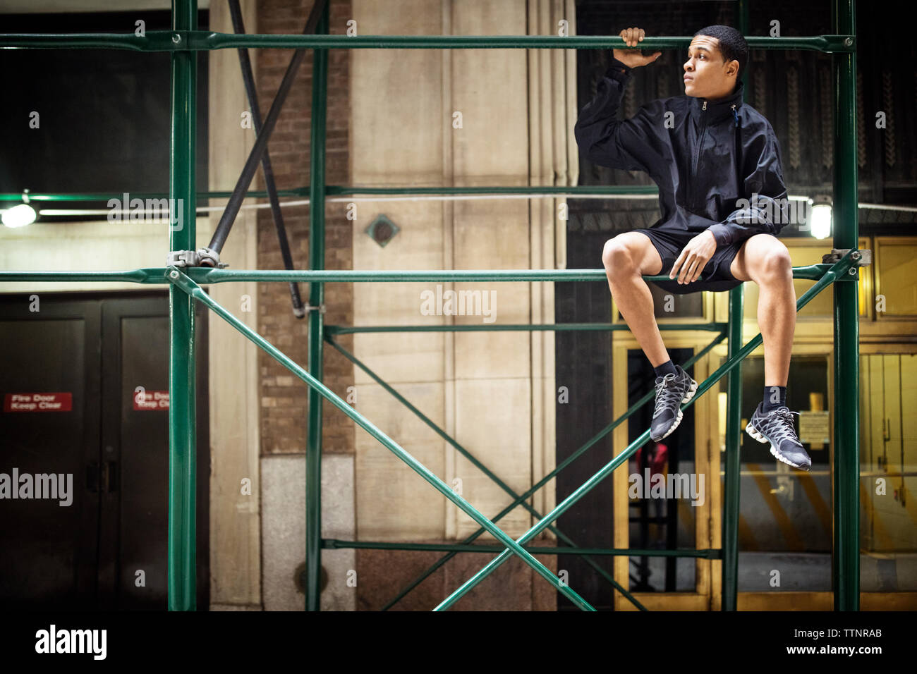 Considerato atleta maschio seduto su asta metallica Foto Stock