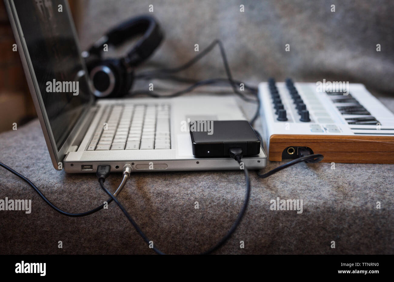 Close-up di computer portatile con tastiera musicale sul divano di casa Foto Stock