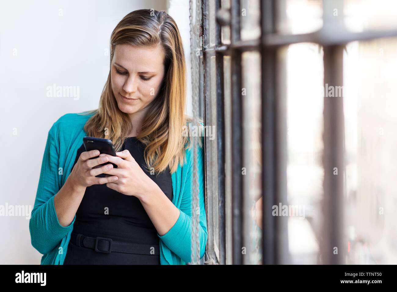 donna d'affari che usa il telefono cellulare in ufficio Foto Stock