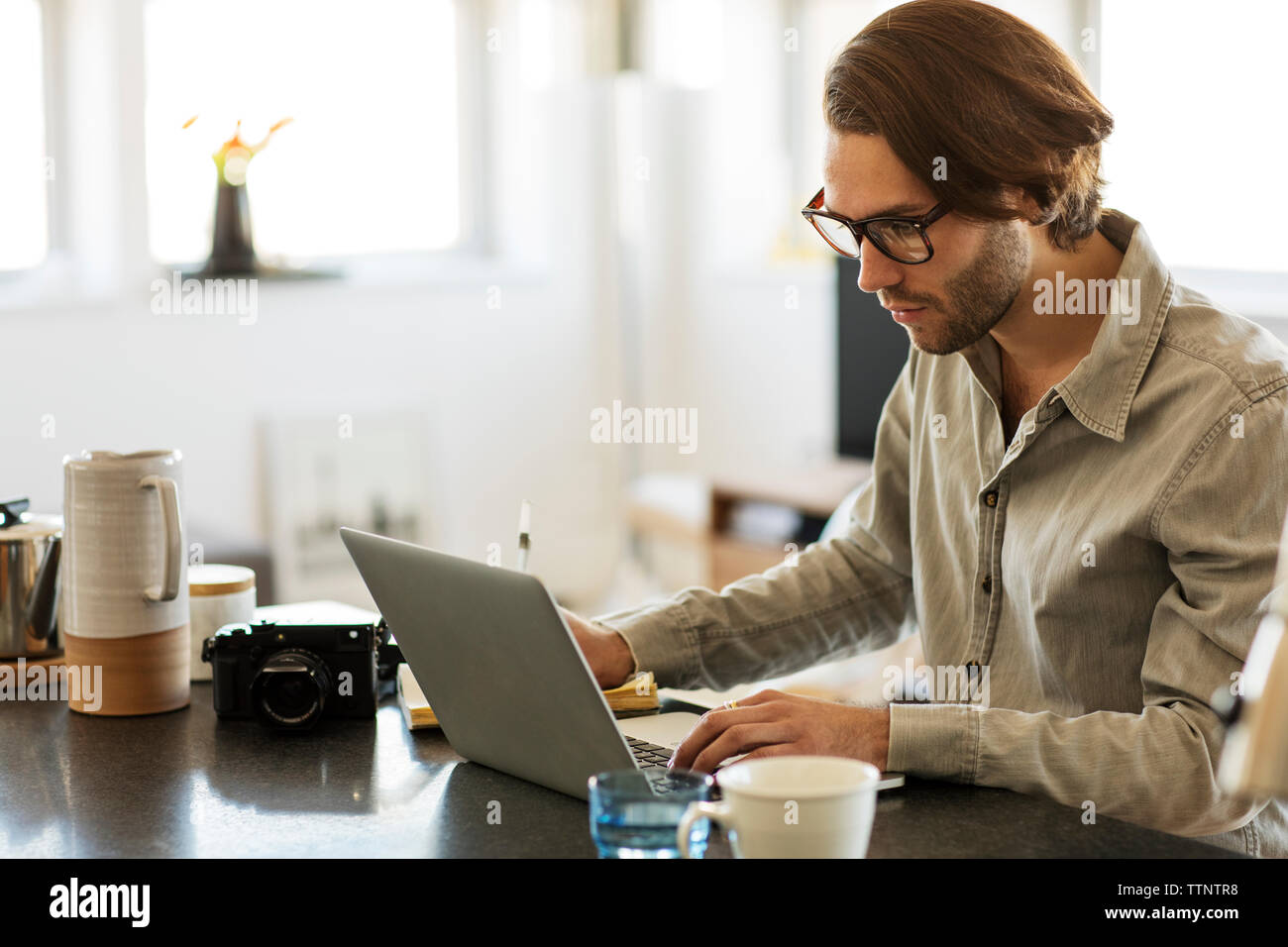 Uomo al lavoro su computer portatile a casa Foto Stock