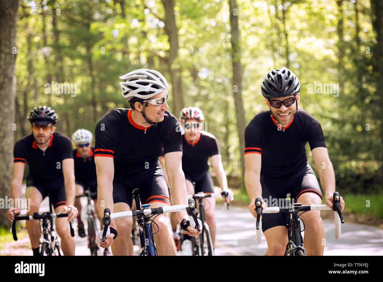 I ciclisti felice di andare in bicicletta sulla strada di campagna Foto Stock